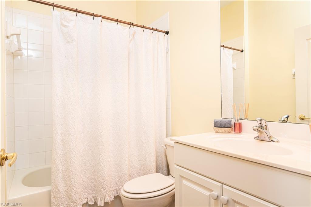 20058 Serre Drive Estero, FL 33928 - Photo 16 of 22 a bathroom with a sink a toilet and shower curtain