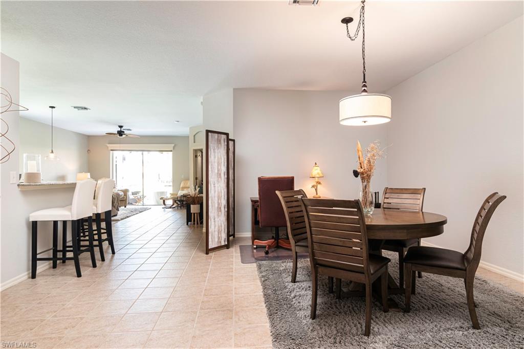 20058 Serre Drive Estero, FL 33928 - Photo 3 of 22 a dining room with furniture a chandelier and wooden floor