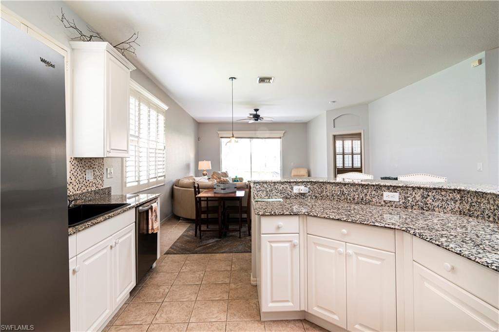 20058 Serre Drive Estero, FL 33928 - Photo 9 of 22 a kitchen with granite countertop a sink stove and cabinets