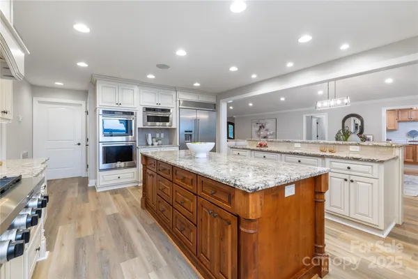 a kitchen with kitchen island granite countertop a large center island and a sink