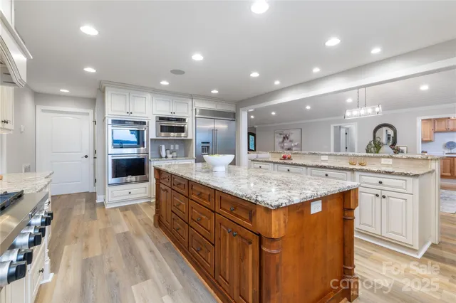 a kitchen with kitchen island granite countertop a large center island and a sink