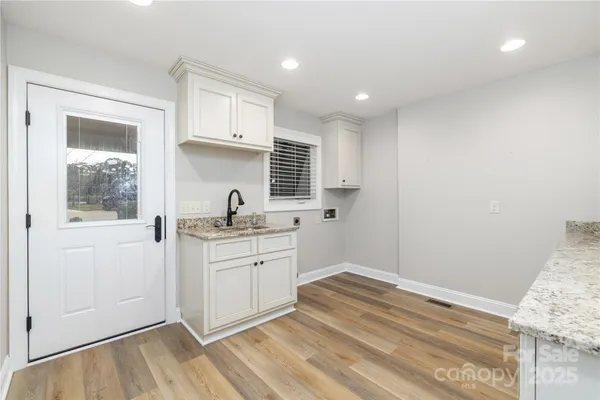 a kitchen with granite countertop white cabinets and white appliances