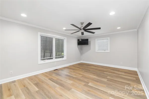 a view of a big room with wooden floor and windows