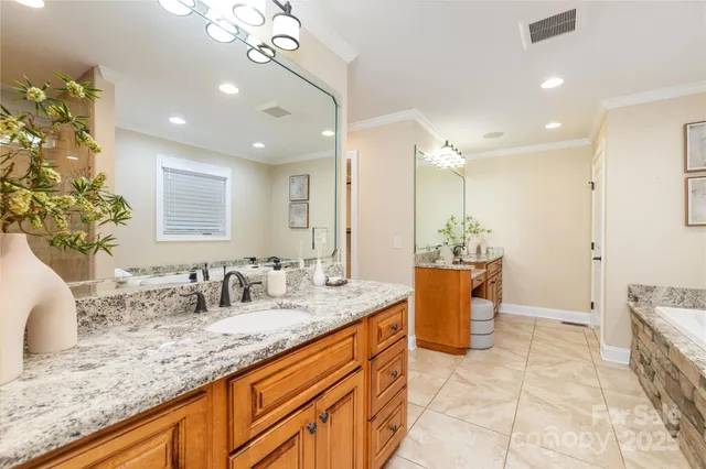 a bathroom with a granite countertop sink a toilet a mirror and bathtub