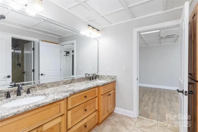 a bathroom with a granite countertop sink double vanity and mirror