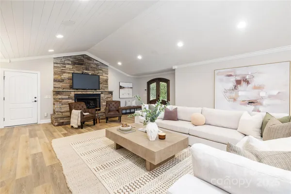 a living room with furniture a fireplace and a flat screen tv