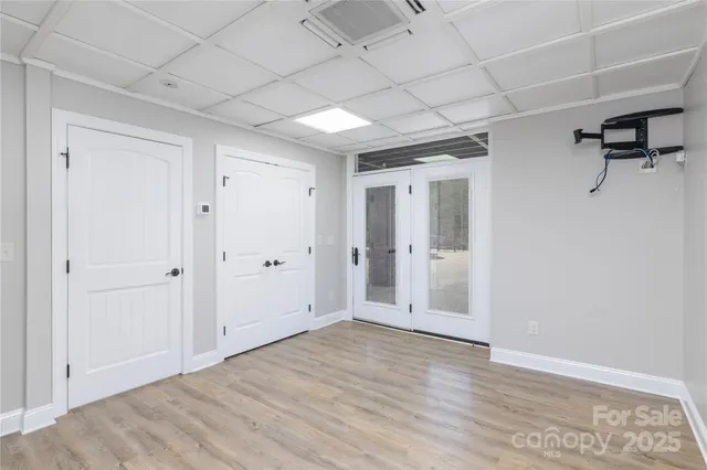 a view of a livingroom with wooden floor and a hallway