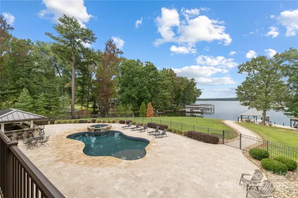 a view of a swimming pool with a patio and a yard