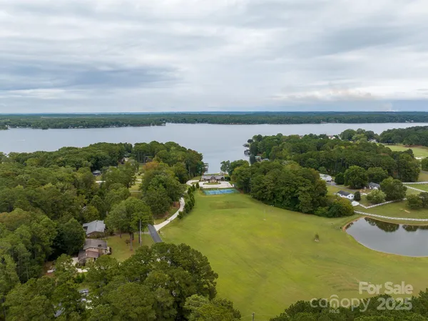 an aerial view of a city with lots of residential buildings ocean and mountain view in back