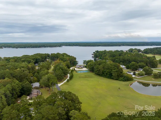 an aerial view of a city with lots of residential buildings ocean and mountain view in back