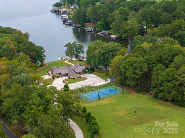 an aerial view of residential houses with outdoor space and trees all around