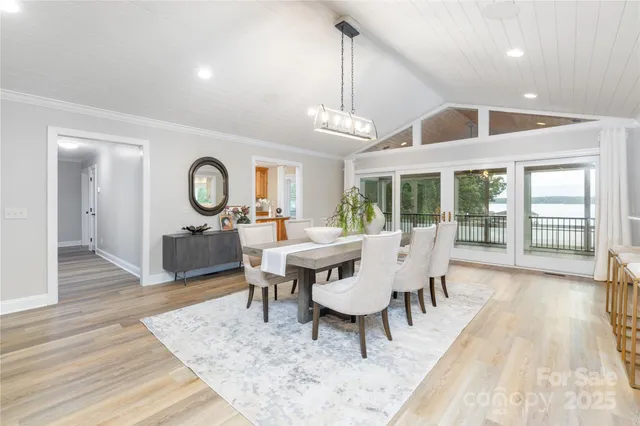 a view of a dining room with furniture a chandelier and wooden floor