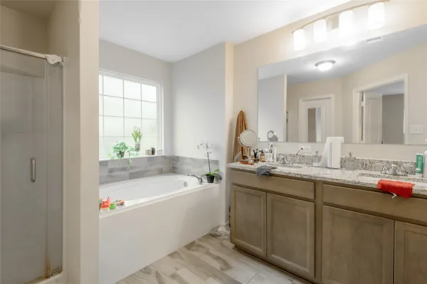 a bathroom with a tub a sink and mirror
