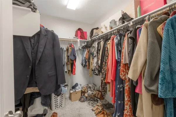 a view of walk in closet with clothes