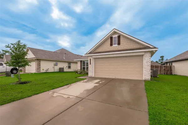 a front view of a house with a yard and garage