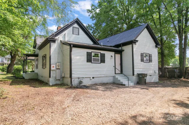 a view of a house with a yard and large tree
