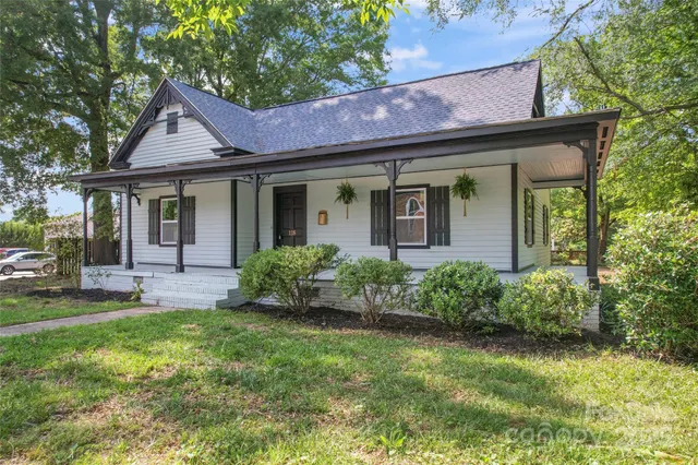 a front view of a house with a garden and yard