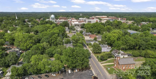 an aerial view of residential house with outdoor space and trees all around