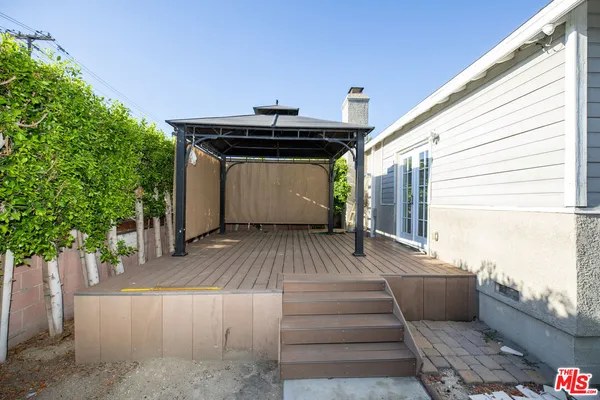a view of a patio with table and chairs with wooden floor and fence