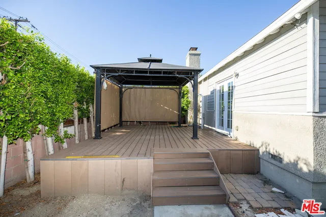 a view of a patio with table and chairs with wooden floor and fence