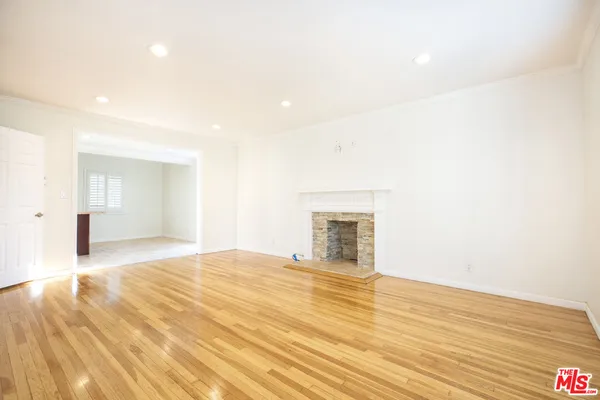 a view of empty room with wooden floor and fireplace