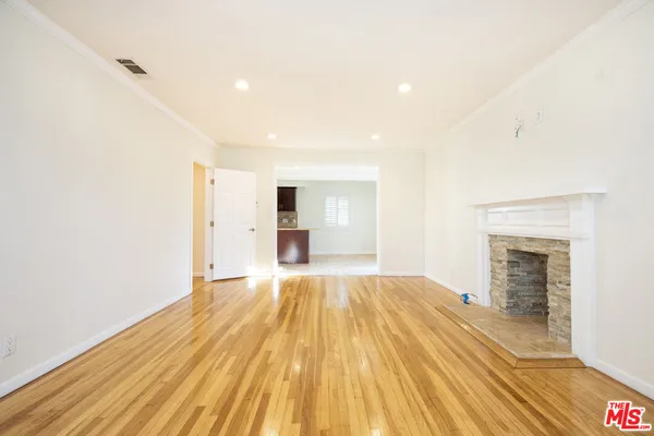 a view of a kitchen with wooden floor and a refrigerator