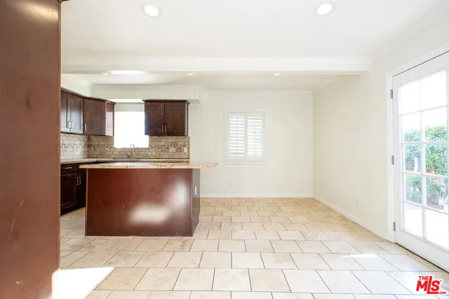 a large kitchen with stainless steel appliances kitchen island granite countertop a refrigerator and a stove top oven