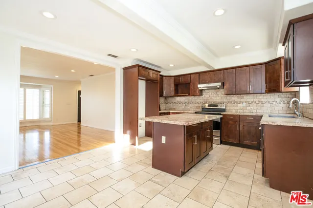 a kitchen with stainless steel appliances granite countertop a refrigerator sink and cabinets