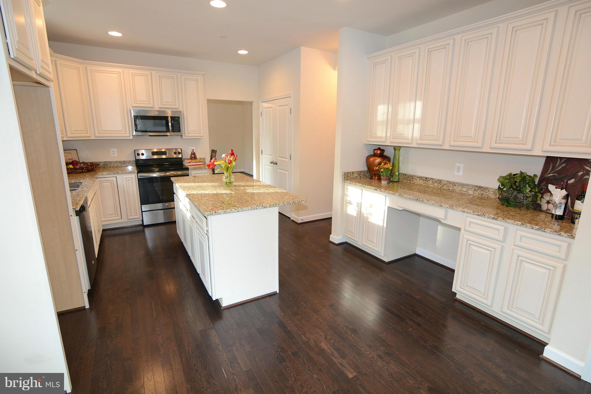 1217 Shesley Road Mayo, MD 21037 - Photo 8 of 30 a kitchen with white cabinets and stainless steel appliances