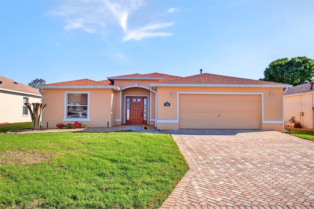 1706 Southwest 156th Lane Ocala, FL 34473 - Photo 1 of 44 a front view of a house with a yard and garage