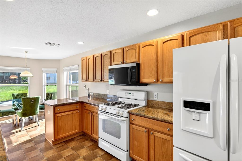 1706 Southwest 156th Lane Ocala, FL 34473 - Photo 11 of 44 a kitchen with a sink a stove cabinets and a refrigerator