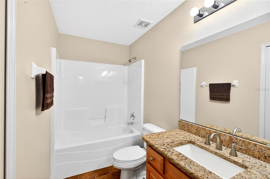 1706 Southwest 156th Lane Ocala, FL 34473 - Photo 24 of 44 a bathroom with a granite countertop sink toilet a shower and a bathtub