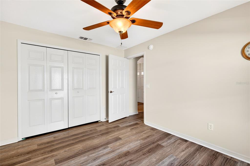 1706 Southwest 156th Lane Ocala, FL 34473 - Photo 26 of 44 a view of a room with wooden floor and a ceiling fan