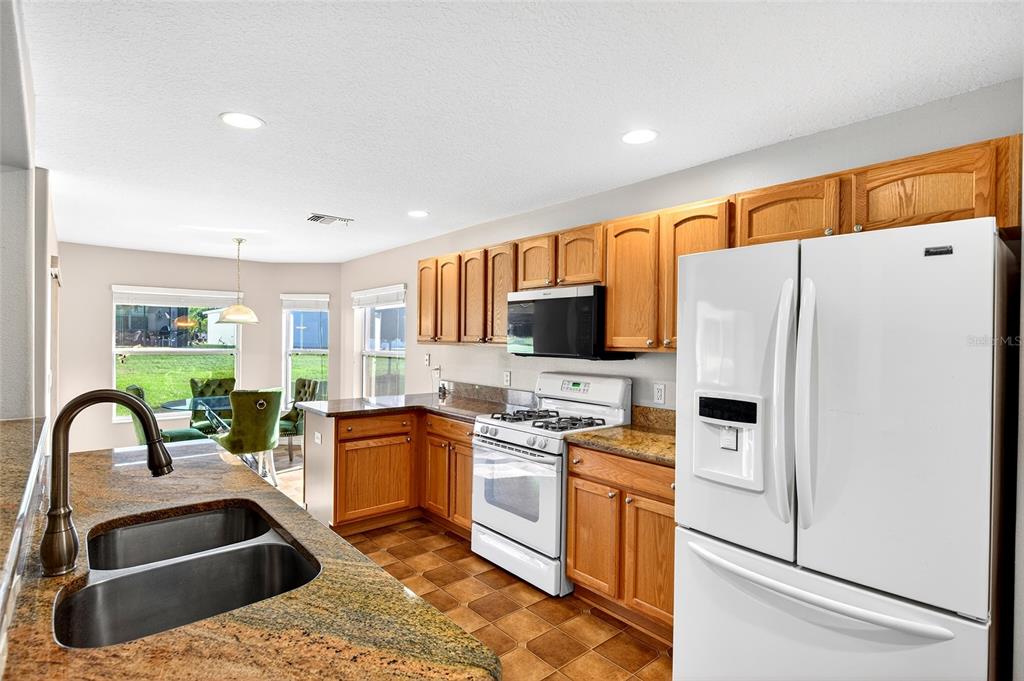 1706 Southwest 156th Lane Ocala, FL 34473 - Photo 8 of 44 a kitchen with stainless steel appliances granite countertop a refrigerator sink and stove