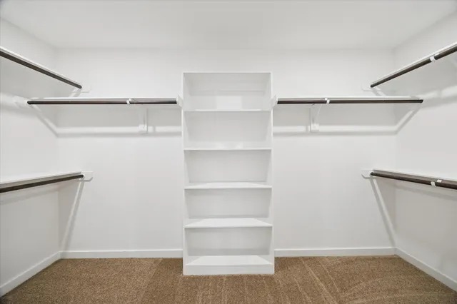 a kitchen with stainless steel appliances a dining table chairs a refrigerator and cabinets