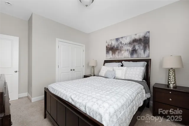 a bedroom with a bed and a lamp on dresser