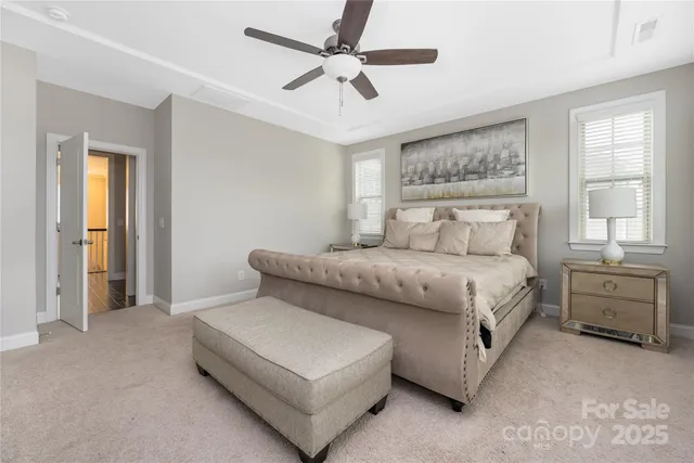 a bedroom with a bed and a chandelier fan