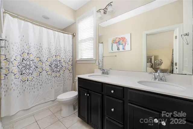 a bathroom with a double vanity sink toilet and a mirror