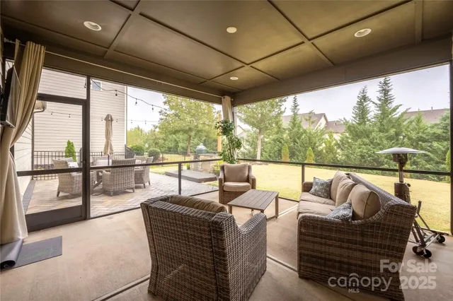 a living room with furniture and a floor to ceiling window