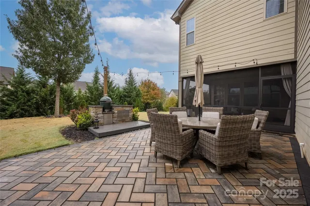 a view of a patio with dining table and chairs with wooden floor and fence