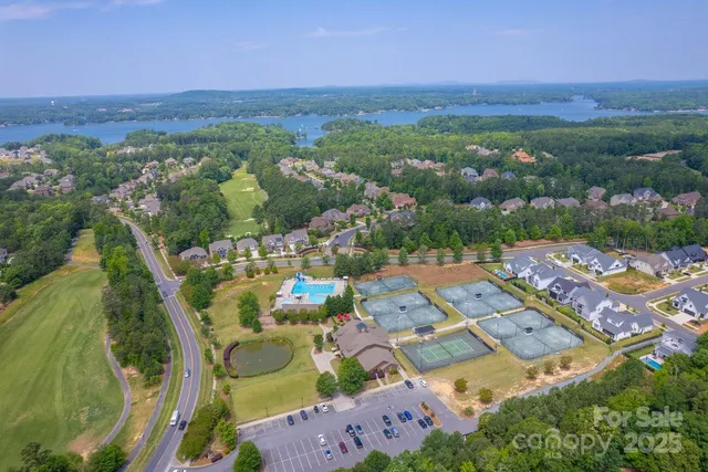 an aerial view of a city with lots of residential buildings ocean and mountain view in back