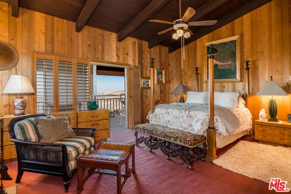 a bedroom with furniture and a flat screen tv