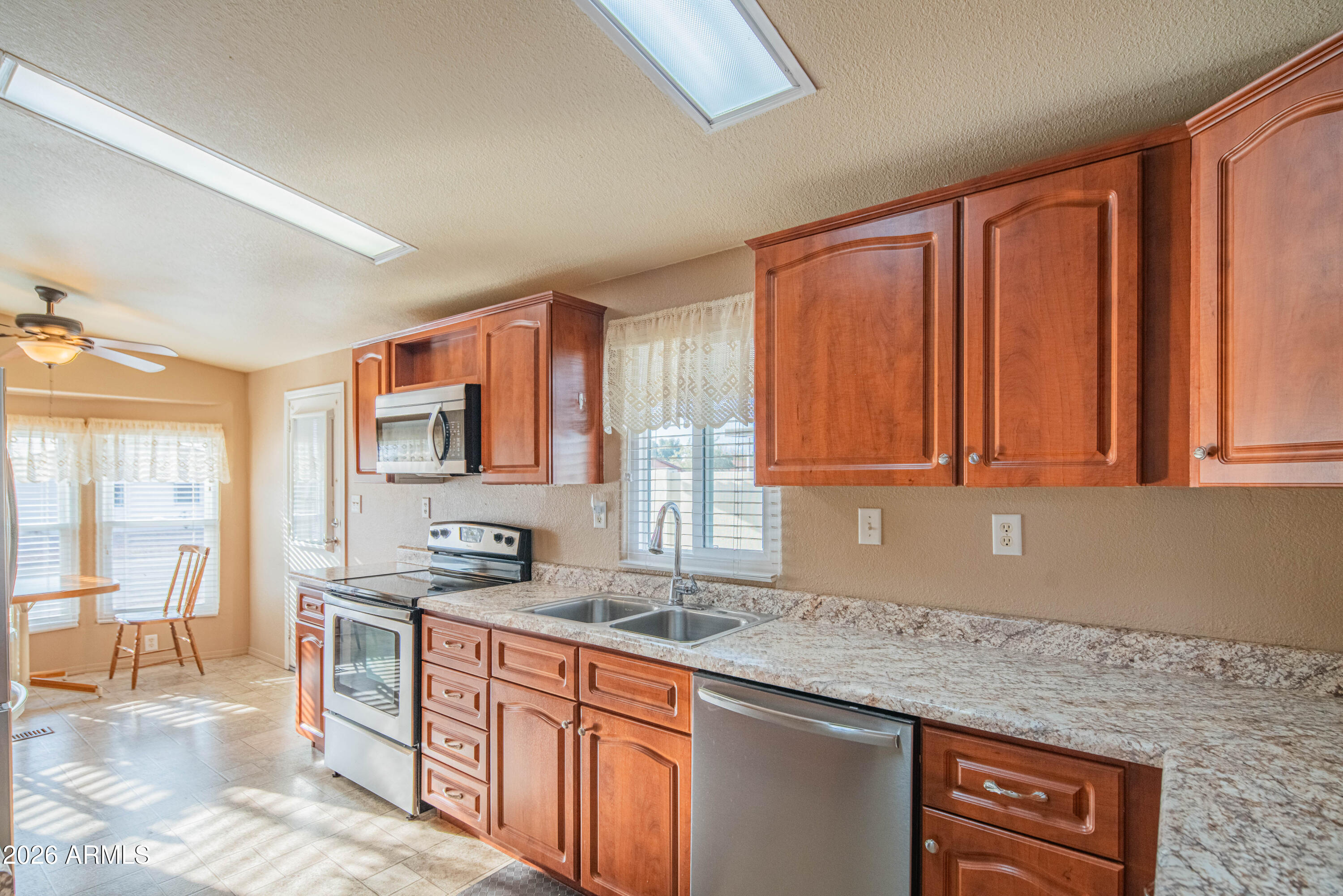 633 South 87th Place Mesa, AZ 85208 - Photo 27 of 55 a kitchen with stainless steel appliances granite countertop a sink stove and cabinets