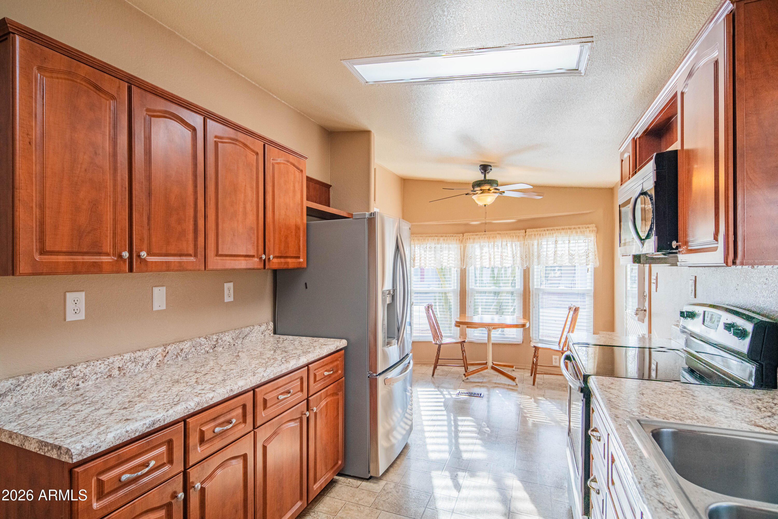633 South 87th Place Mesa, AZ 85208 - Photo 29 of 55 a kitchen with stainless steel appliances granite countertop a refrigerator a sink dishwasher a dining table and chairs with wooden floor