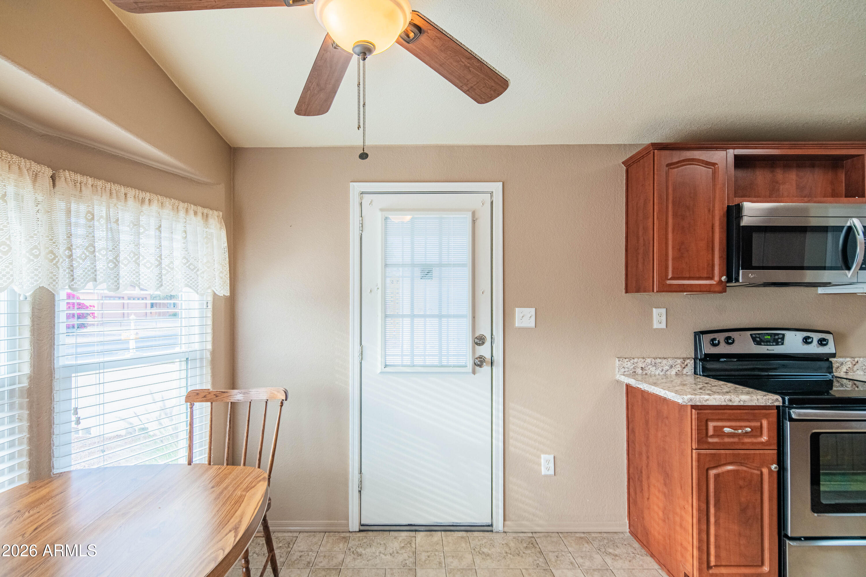 633 South 87th Place Mesa, AZ 85208 - Photo 35 of 55 a kitchen with stainless steel appliances kitchen island granite countertop a refrigerator a stove a microwave oven with a dining table and chairs