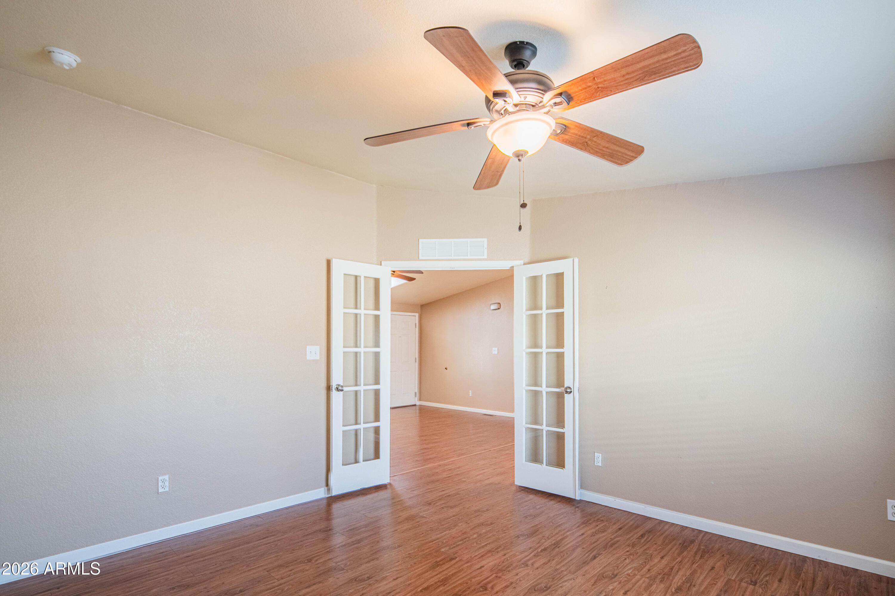 633 South 87th Place Mesa, AZ 85208 - Photo 45 of 55 an empty room with wooden floor a ceiling fan and a window