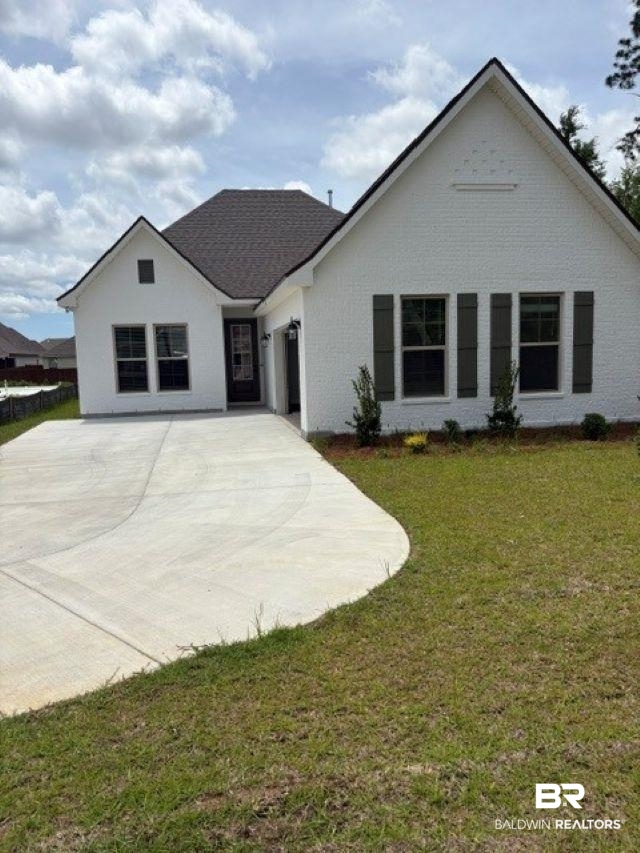 401 Sutton Lane Foley, AL 36535 - Photo 1 of 3 White brick exterior featuring a dark asphalt shingle roof