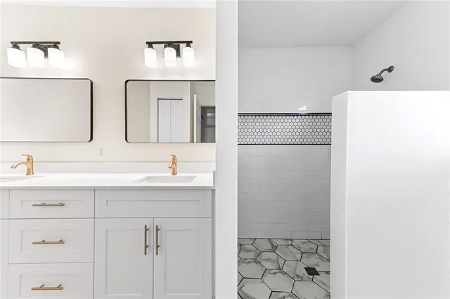 a bathroom with a sink a mirror and a shower
