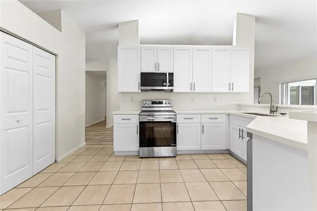 a kitchen with a stove sink and cabinets