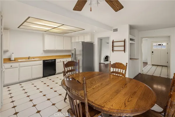 a kitchen with stainless steel appliances kitchen island granite countertop a sink a stove a dining table and chairs